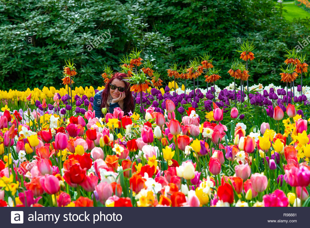 pretty girl smiling amongst the beautiful spring flowers in the keukenhof gardens lisse holland the netherlands R