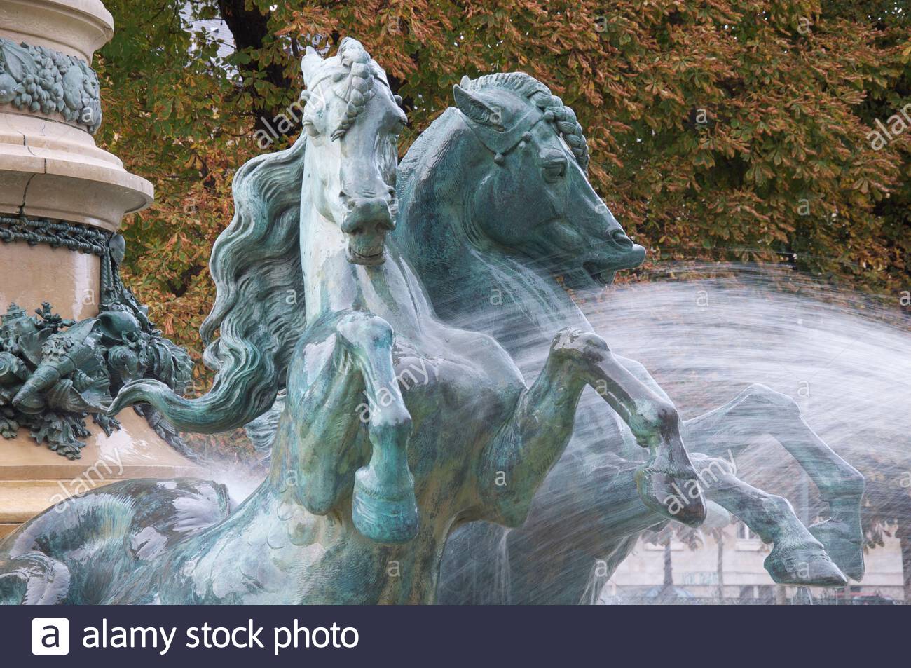 sculptures of galloping horses charging through the water jets of the monumental fontaine de lobservatoire in the jardin marco polo paris france 2AXW607