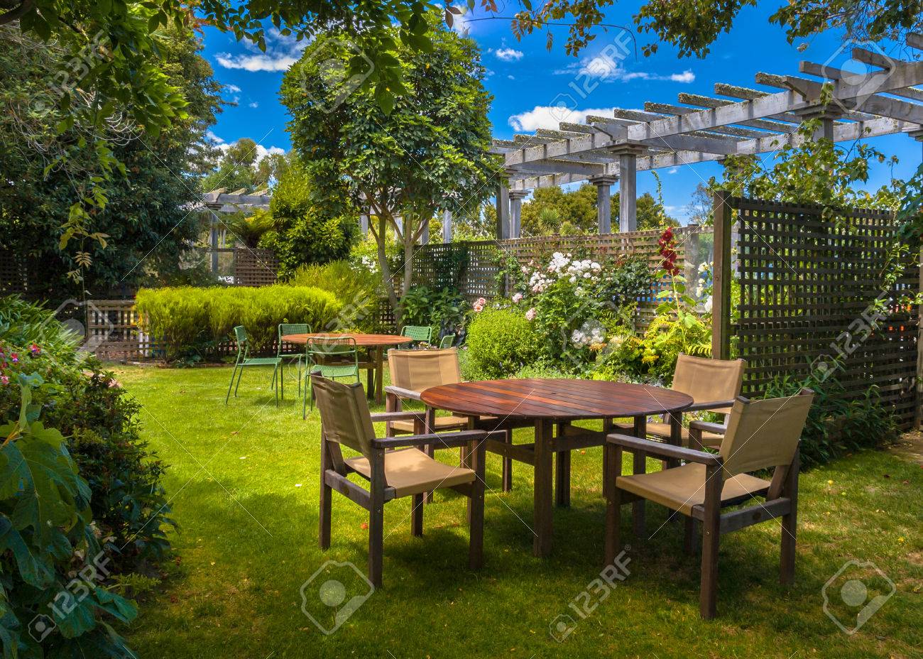accueil cour avec table de jardin sous le soleil d un jardin luxuriant à l ombre des arbres