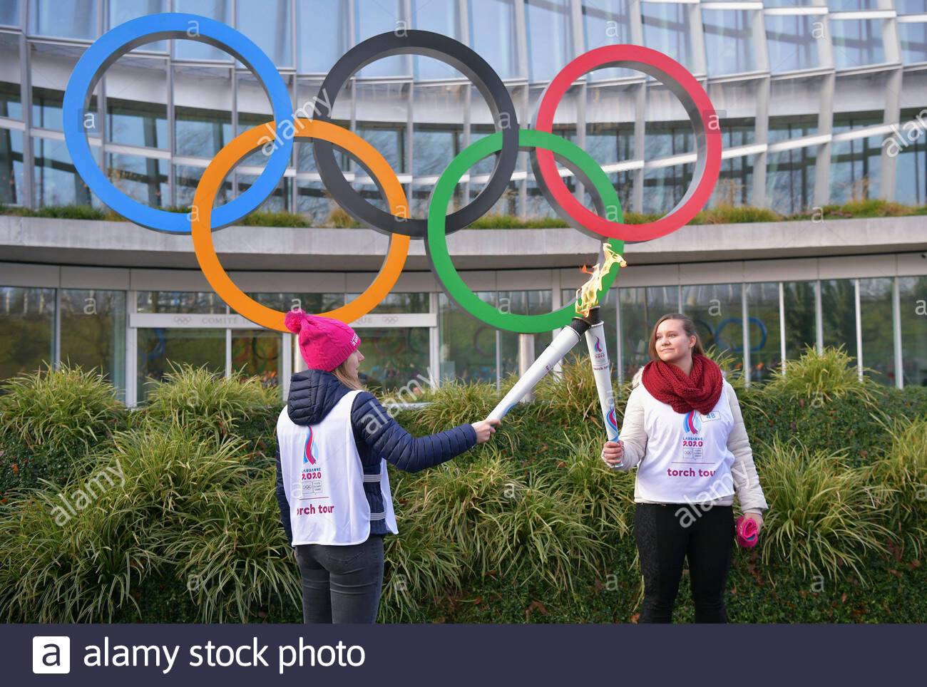 lausanne jan 8 2020 xinhua torch bearer christelle boivin l passes the torch to aurore locher during a torch relay for the 3rd youth winter olympic games in lausanne switzerland jan 8 2020 xinhuawang qingqin 2AKAY07