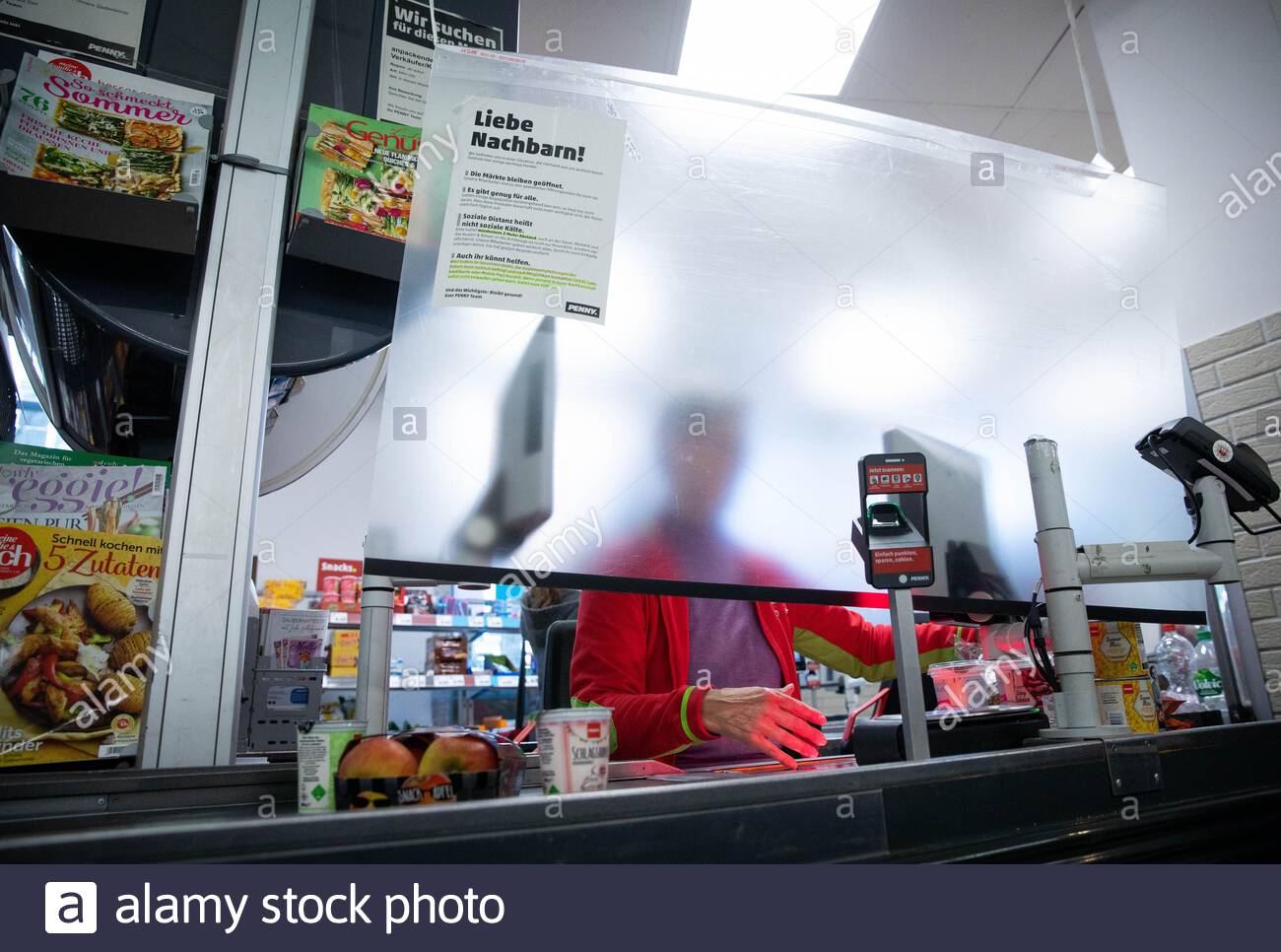 hamburg germany 23rd mar 2020 temporary protective measures protect cashiers in a penny branch in many branches of aldi lidl netto rewe penny and other supermarkets and stores plexiglas panes and other devices are currently installed as spit protection at the cash registers according to a survey of supermarket and discount store chains by the german press agency in order to slow down the spread of the corona virus the federal government has further considerably restricted public life the novel coronavirus is mainly transmitted by droplet infection photo christian charisiu 2B9331T