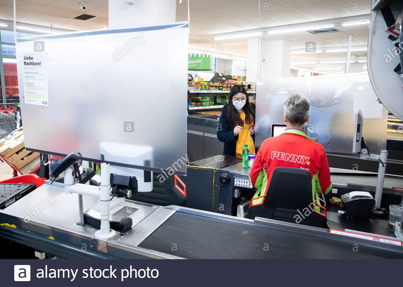 hamburg germany 23rd mar 2020 temporary protective measures protect cashiers in a penny branch in many branches of aldi lidl netto rewe penny and other supermarkets and stores plexiglas panes and other devices are currently installed as spit protection at the cash registers according to a survey of supermarket and discount store chains by the german press agency in order to slow down the spread of the corona virus the federal government has further considerably restricted public life the novel coronavirus is mainly transmitted by droplet infection photo christian charisiu 2B9332X