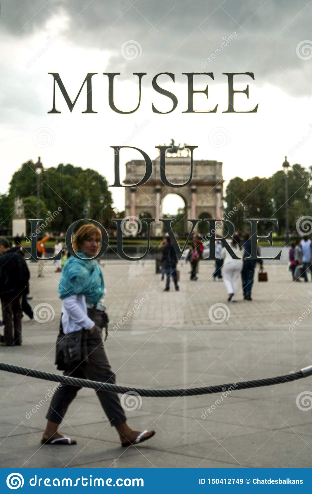 tourist passing behind logo louvre museum musee du louvre front jardin des tuileries garden paris france july