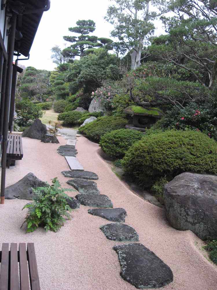 aménagement jardin en pente japonais gravier décoratif arbustes taillés allée pierre naturelle